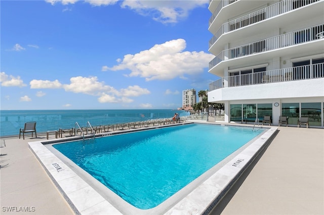 pool with a water view and a patio area