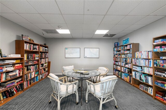 carpeted dining space with baseboards and a drop ceiling