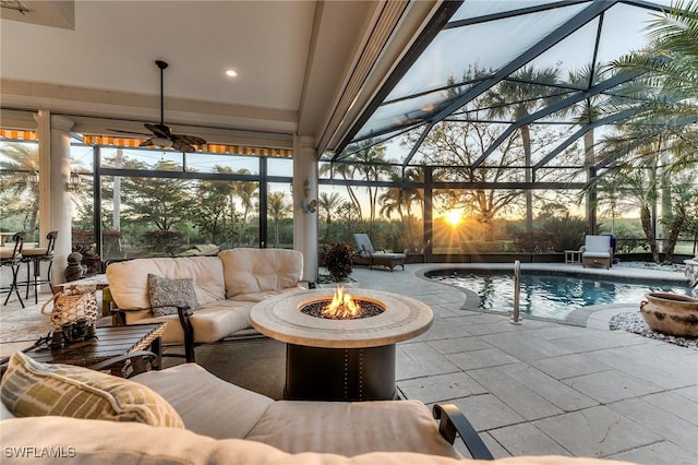 view of pool featuring a fenced in pool, an outdoor living space with a fire pit, a patio, a ceiling fan, and glass enclosure