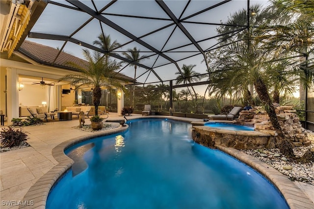 view of pool featuring a patio, glass enclosure, and a pool with connected hot tub