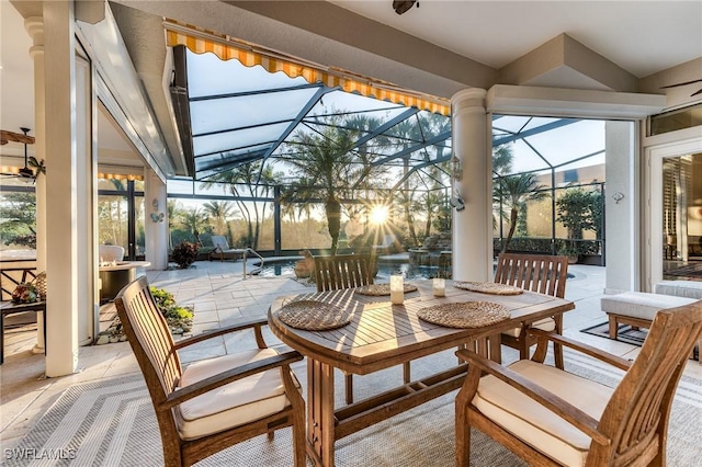 view of patio with a lanai, outdoor dining area, and an outdoor pool