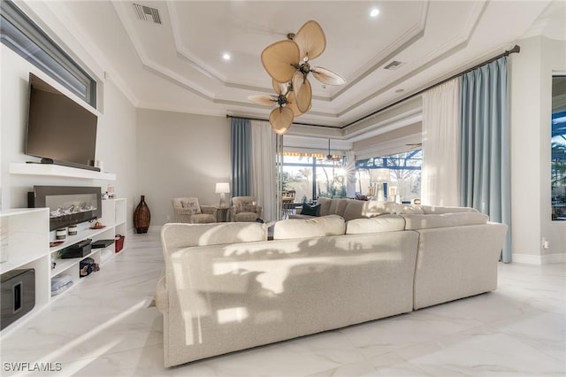 living room with visible vents, a raised ceiling, and ornamental molding