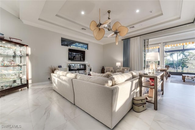 living area featuring visible vents, a tray ceiling, and ornamental molding