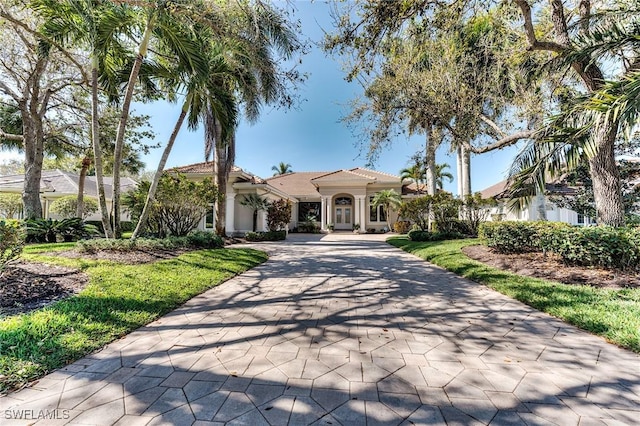 mediterranean / spanish home featuring decorative driveway and stucco siding