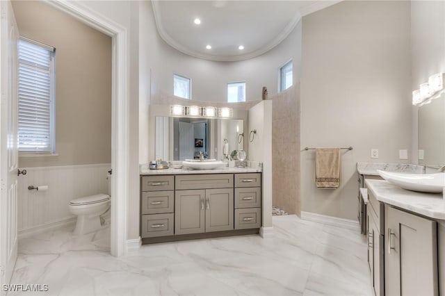 bathroom with marble finish floor, ornamental molding, walk in shower, and a sink