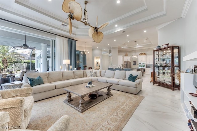 living area featuring ornamental molding, a tray ceiling, visible vents, and ceiling fan with notable chandelier