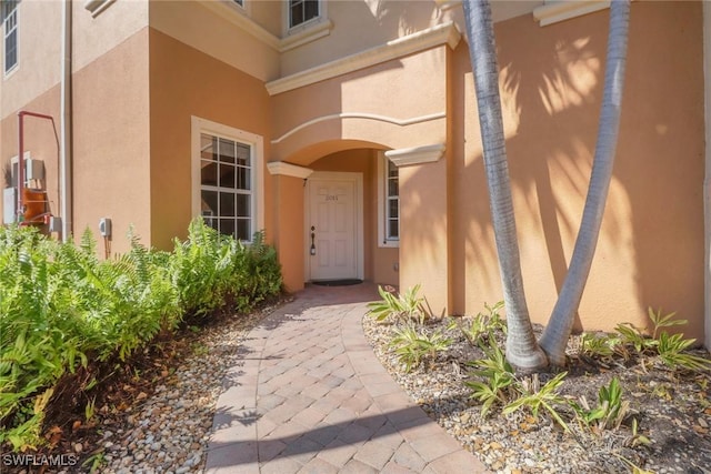 doorway to property with visible vents and stucco siding