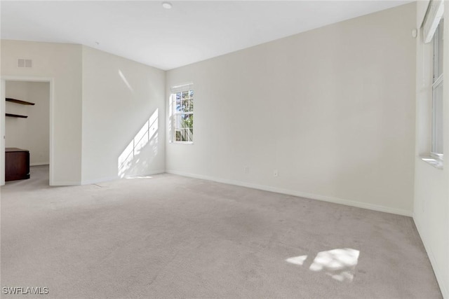 carpeted empty room with visible vents and baseboards