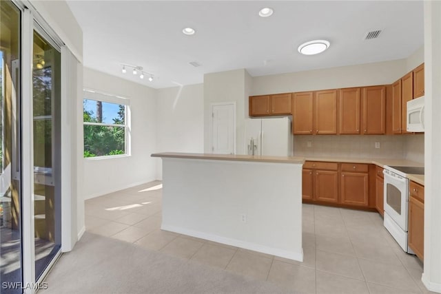 kitchen featuring white appliances, light tile patterned floors, visible vents, decorative backsplash, and light countertops