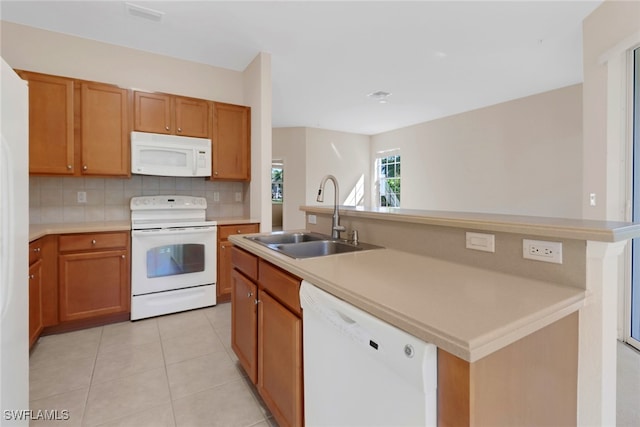 kitchen featuring white appliances, visible vents, light tile patterned flooring, a sink, and tasteful backsplash