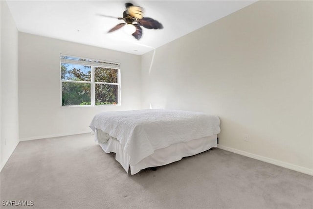 bedroom featuring a ceiling fan, light colored carpet, and baseboards