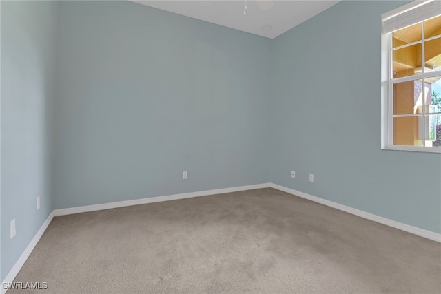 unfurnished room with carpet, baseboards, and ceiling fan