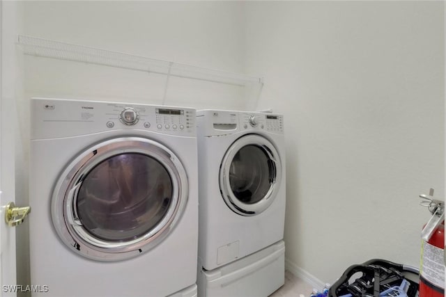 laundry area with laundry area, baseboards, and washer and clothes dryer