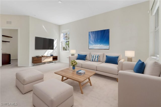 living area with light colored carpet, visible vents, and baseboards