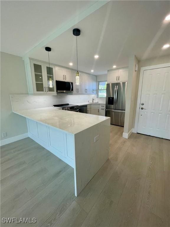 kitchen featuring a peninsula, light wood-style floors, white cabinetry, and stainless steel appliances