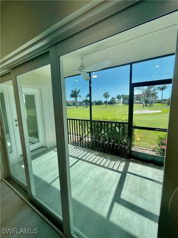 doorway to outside with ceiling fan and wood finished floors