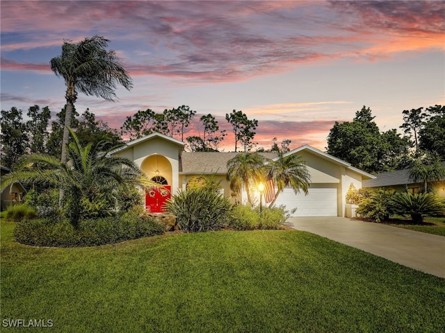 view of front of home with a garage, stucco siding, driveway, and a front yard