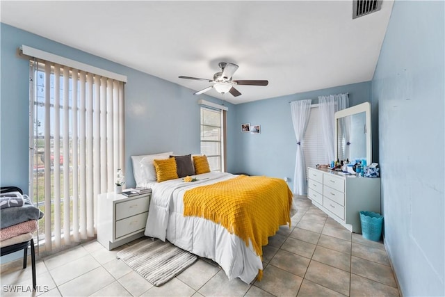 tiled bedroom featuring a ceiling fan, access to outside, visible vents, and multiple windows