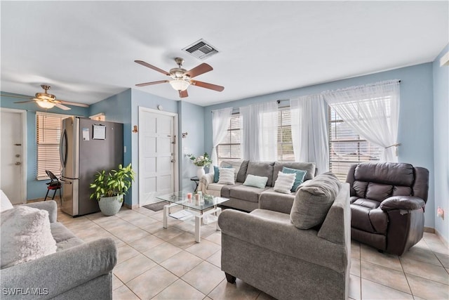 living area with visible vents, ceiling fan, baseboards, and light tile patterned flooring