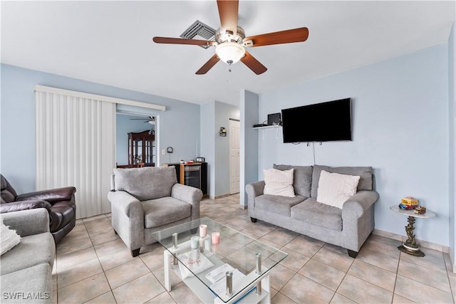 living area featuring baseboards, a ceiling fan, and light tile patterned flooring