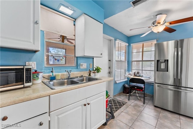 kitchen with stainless steel appliances, a sink, visible vents, a ceiling fan, and white cabinets