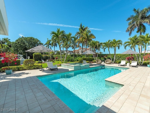 view of pool with a patio area and a pool with connected hot tub