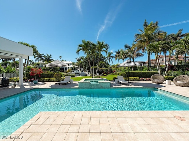 view of pool featuring a patio and a pool with connected hot tub