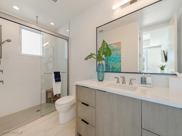 full bath featuring recessed lighting, a shower stall, toilet, and vanity