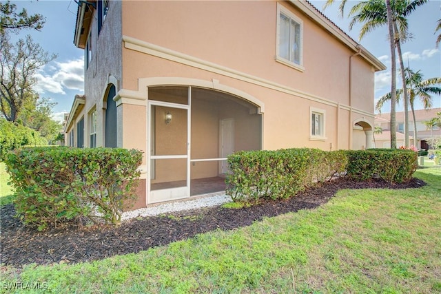 17545 Cherry Ridge Ln, Fort Myers, FL 33967 - back of property featuring a sunroom, a yard, and stucco siding