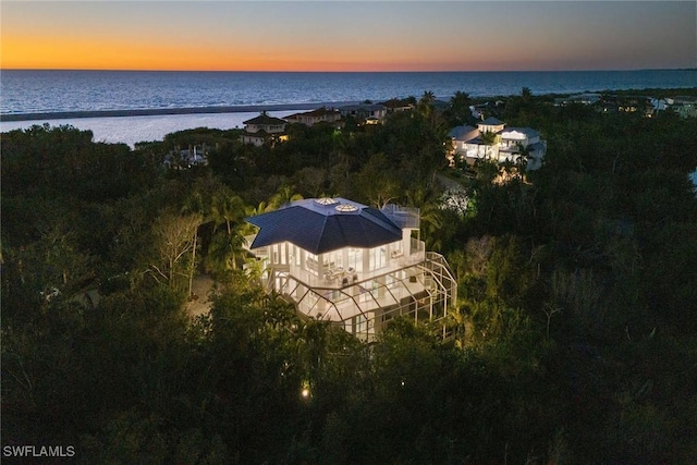 aerial view at dusk featuring a water view