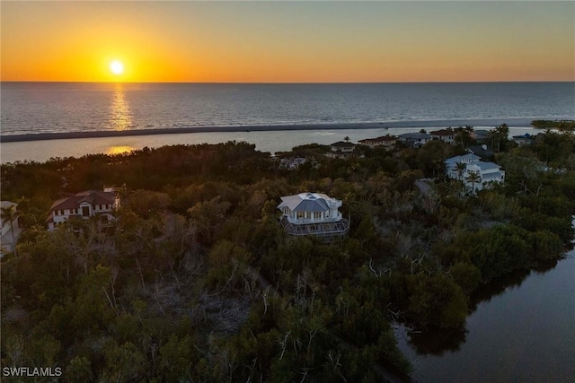 aerial view at dusk featuring a water view