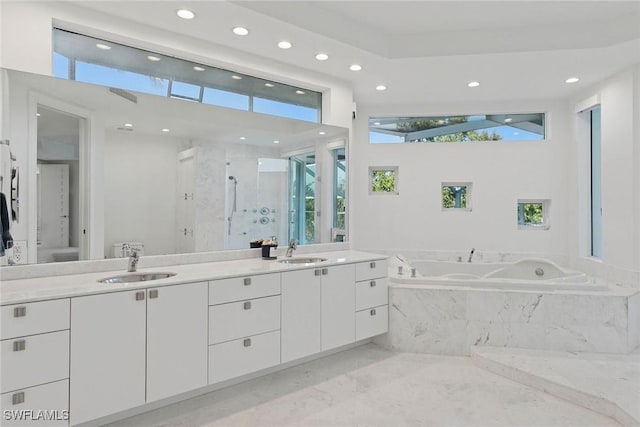 bathroom featuring marble finish floor, a stall shower, a sink, recessed lighting, and double vanity