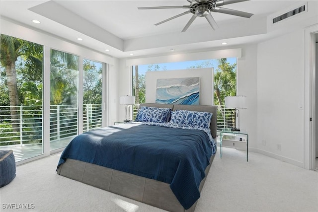 bedroom with recessed lighting, visible vents, a raised ceiling, and access to exterior