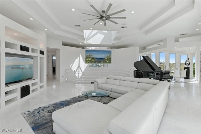 living area with visible vents, recessed lighting, marble finish floor, and a tray ceiling