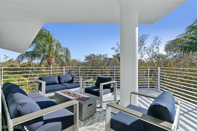 view of patio / terrace with an outdoor living space with a fire pit and a balcony