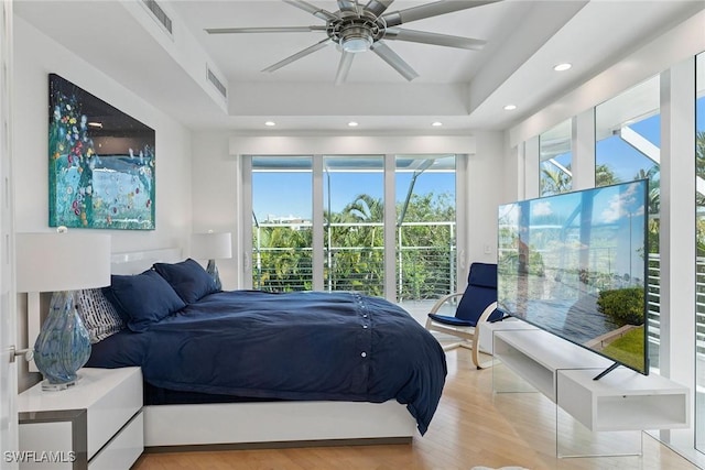 bedroom featuring a tray ceiling, recessed lighting, and visible vents
