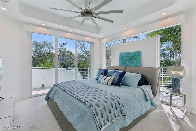 bedroom with a ceiling fan, carpet floors, a tray ceiling, recessed lighting, and access to outside