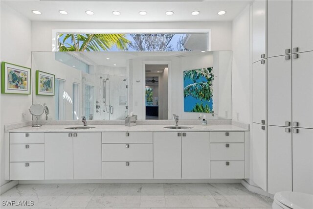 full bath featuring double vanity, a stall shower, marble finish floor, and a sink