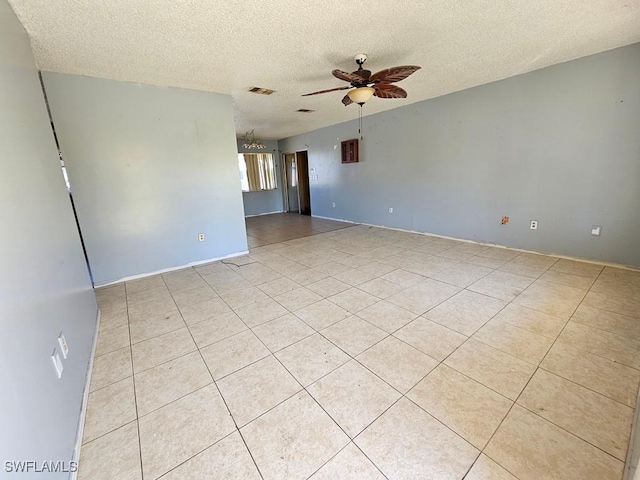 empty room with visible vents, a textured ceiling, and a ceiling fan