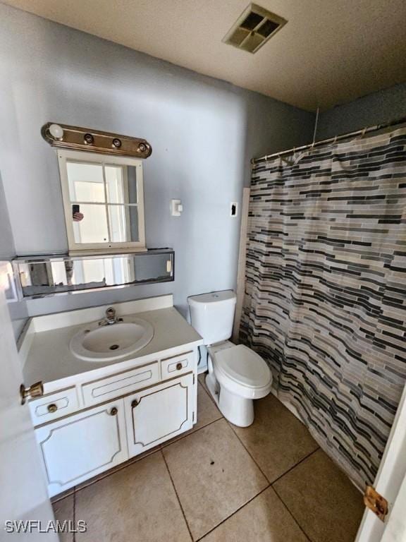 bathroom featuring a shower with curtain, visible vents, toilet, vanity, and tile patterned flooring