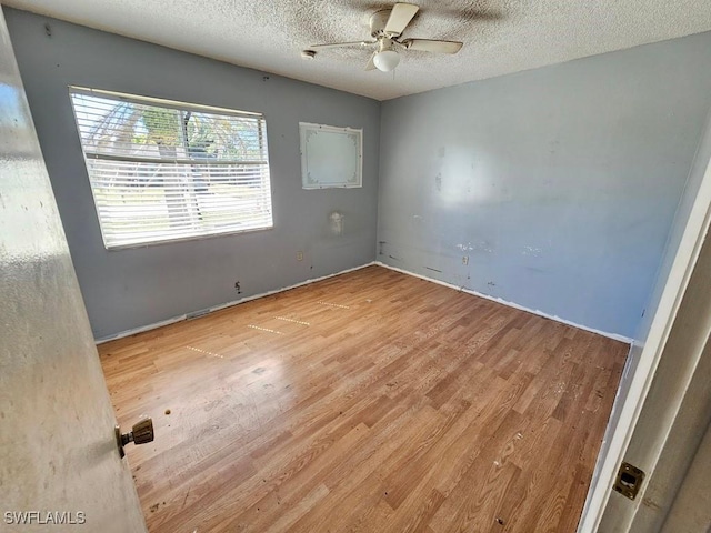 spare room featuring ceiling fan, a textured ceiling, and wood finished floors