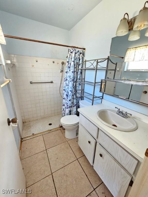 full bath with tile patterned flooring, a shower stall, toilet, and vanity