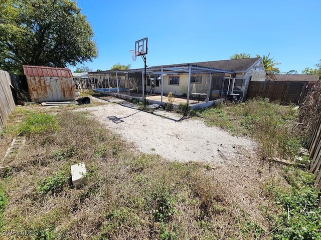 view of yard with a fenced backyard, a shed, a patio, and an outbuilding