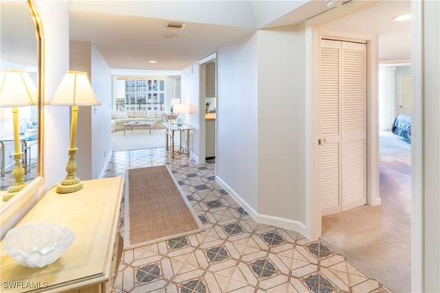 hallway with visible vents and baseboards