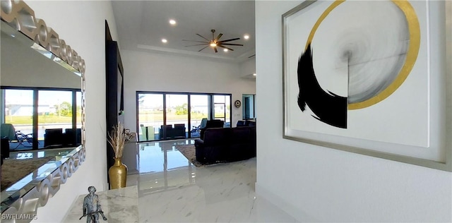 hallway featuring recessed lighting, marble finish floor, and a towering ceiling