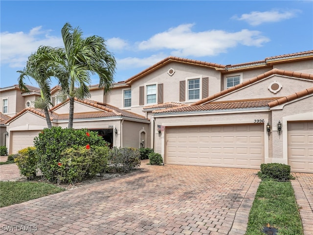 view of front facade featuring decorative driveway, a tile roof, and stucco siding