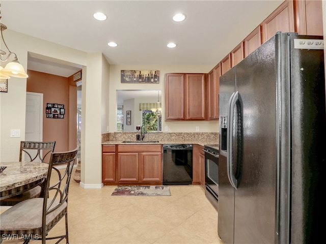 kitchen with black appliances, brown cabinetry, a sink, and recessed lighting