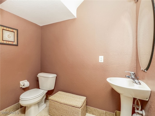 bathroom featuring toilet and baseboards