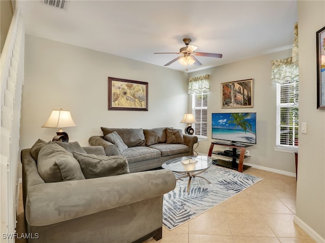 living area with light tile patterned floors, baseboards, visible vents, and a wealth of natural light