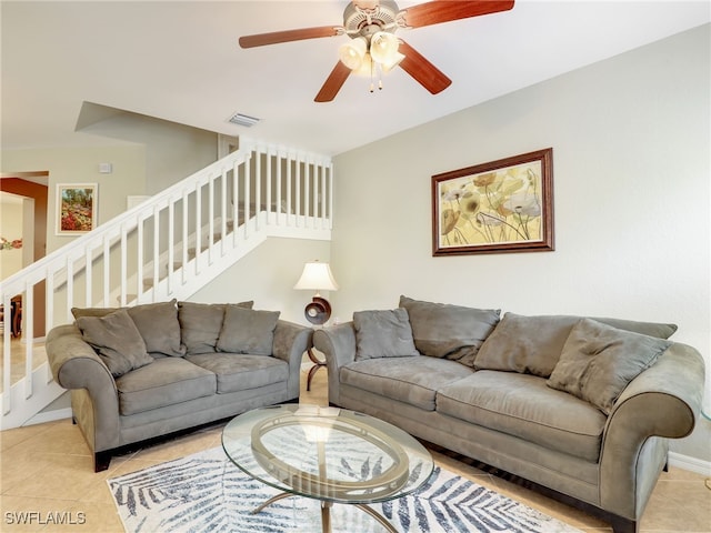 living room featuring stairs, visible vents, and light tile patterned flooring